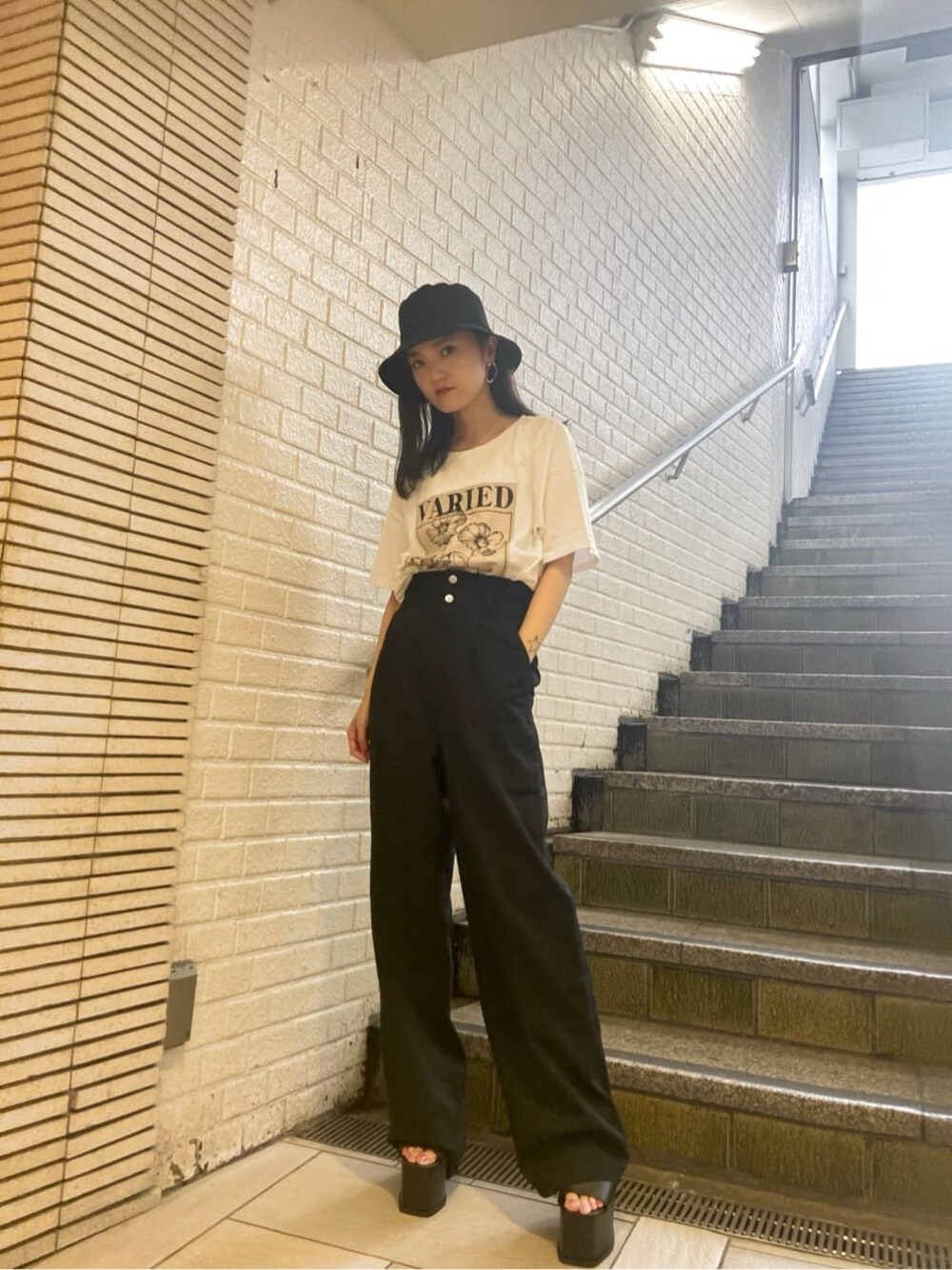 ブラック系のサンダル、ブラック系のその他パンツ、ホワイト系のTシャツ/カットソーを着用したレディースの夏コーディネートの1枚目の写真