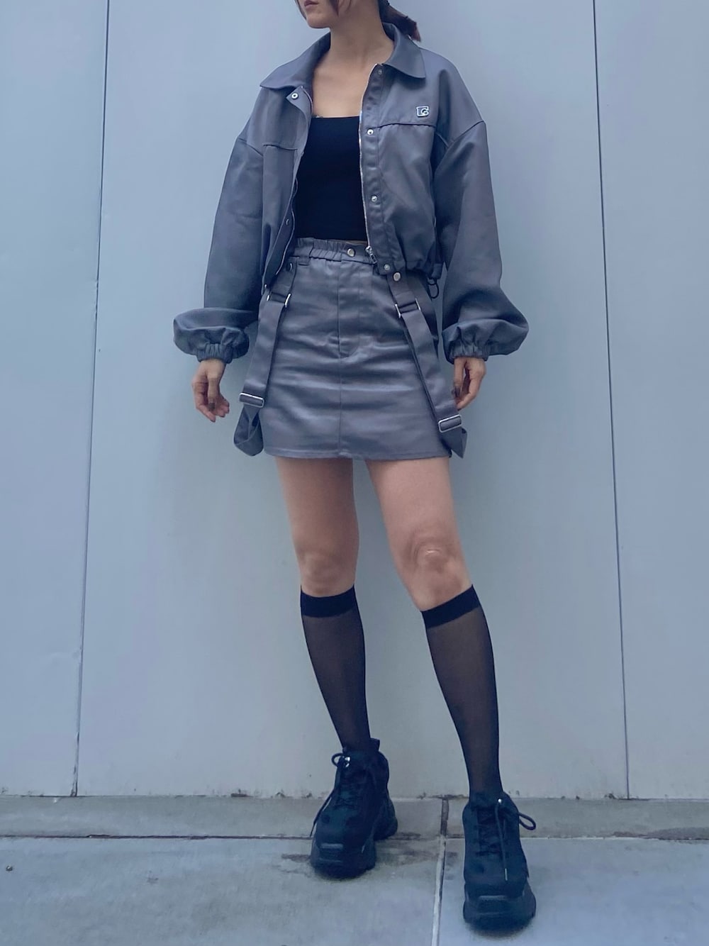グレー系のブルゾン、ブラック系のキャミソール、グレー系のスカートを着用したレディースの冬コーディネートの1枚目の写真