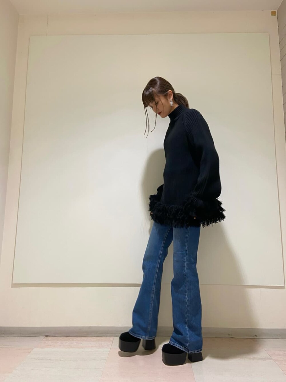 ブラック系のブーツ、ブルー系のデニムパンツ、ブラック系のニット/セーターを着用したレディースの冬コーディネートの1枚目の写真