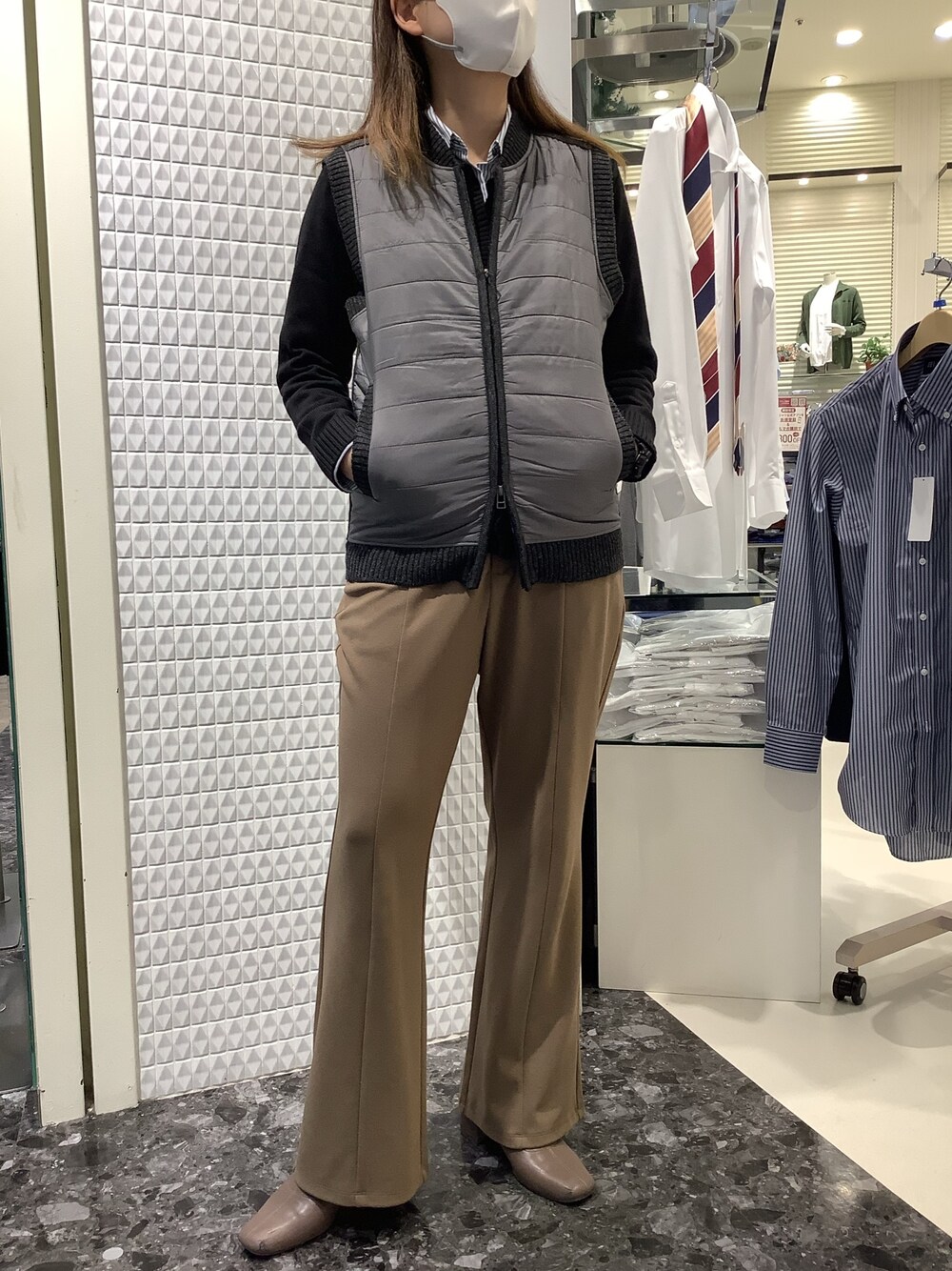 グレー系のニット/セーター、ブラック系のカーディガン/ボレロ、ブルー系のビジネスシャツを着用したレディースの秋コーディネートの1枚目の写真