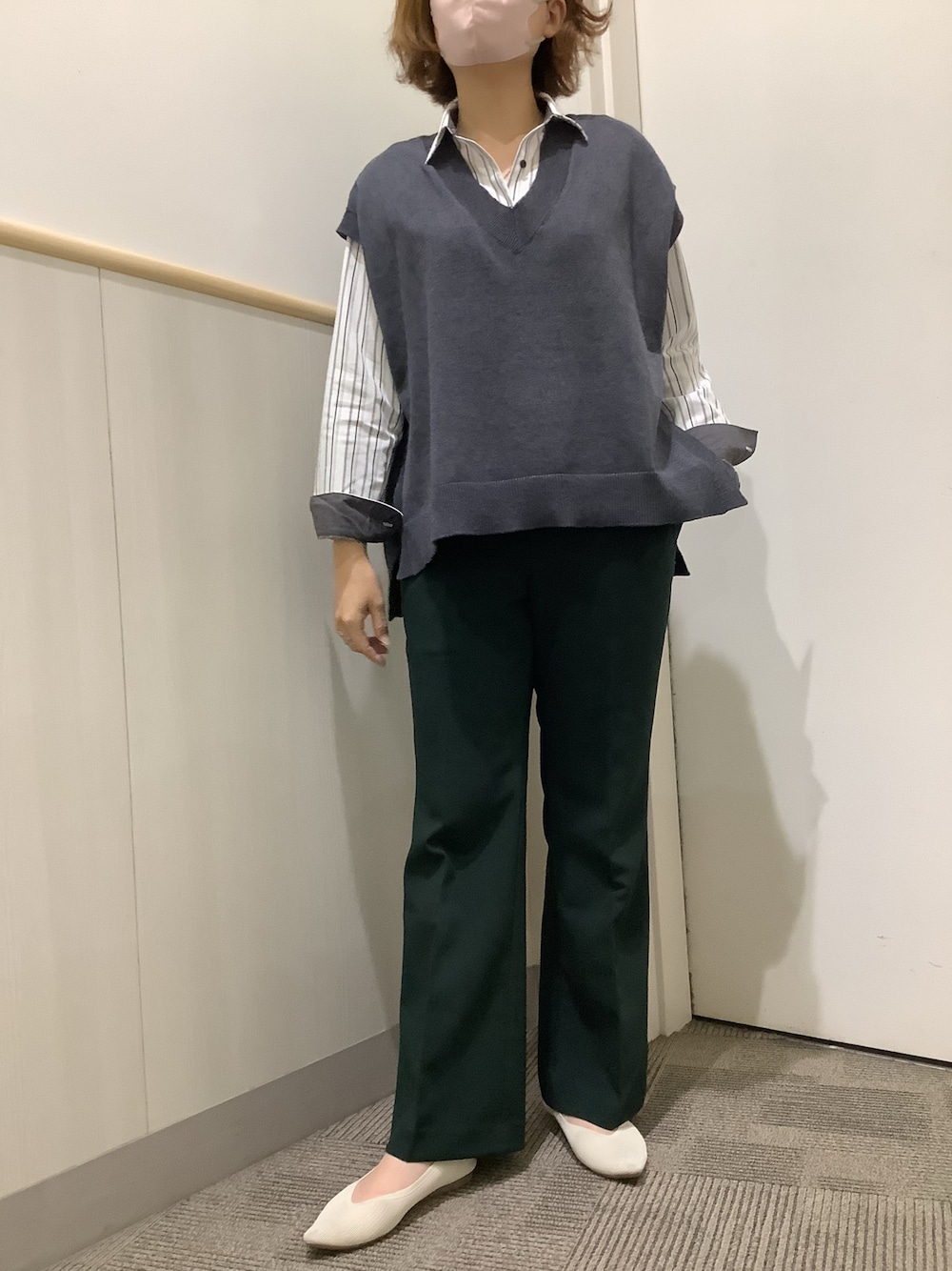 グレー系のビジネスシャツ、グレー系のベストを着用したレディースの秋コーディネートの1枚目の写真