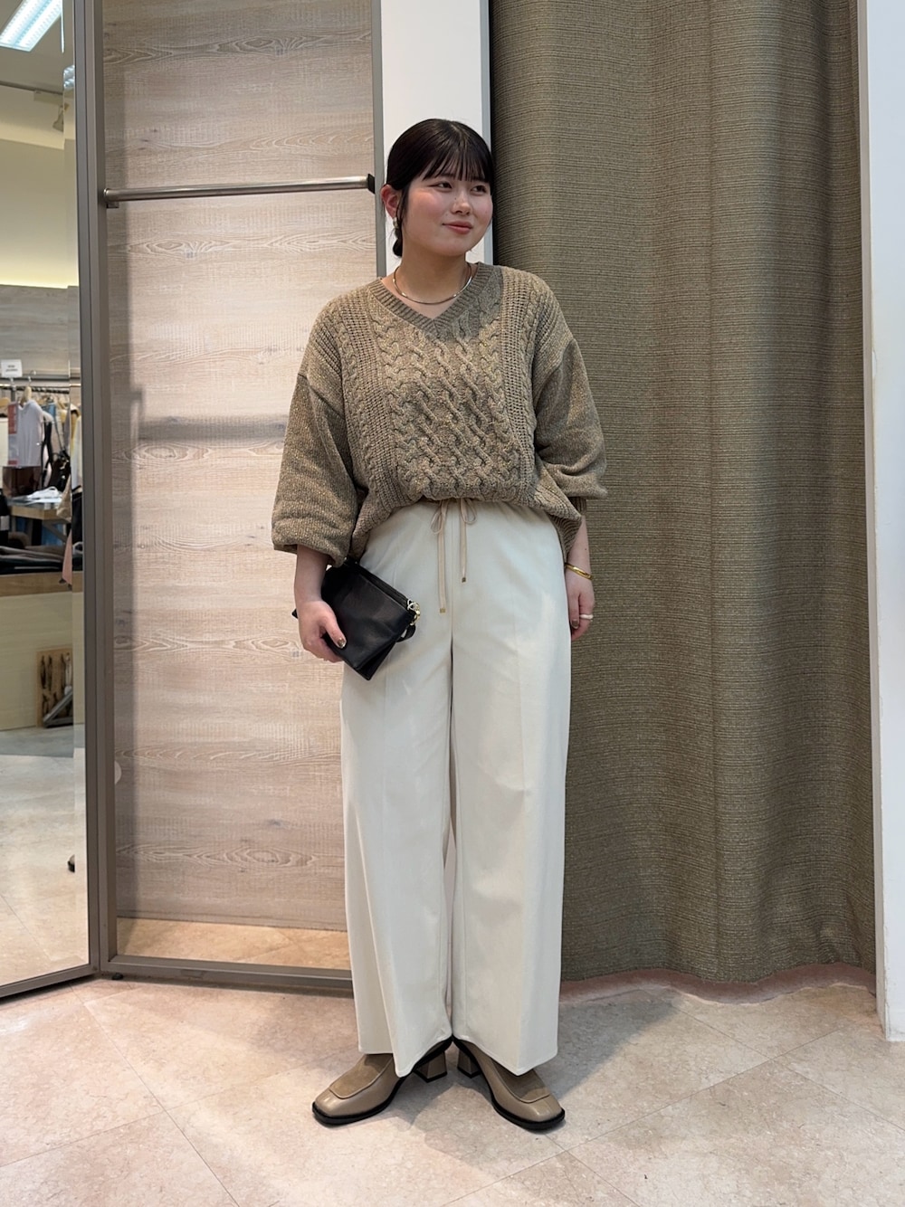 グレー系のニット/セーター、ホワイト系のその他パンツ、ブラック系のトートバッグを着用したレディースの冬コーディネートの1枚目の写真