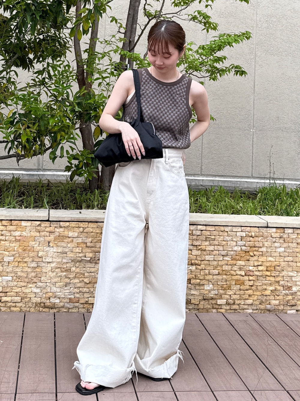 ブラウン系のタンクトップ、ホワイト系のデニムパンツ、ブラック系のサンダルを着用したレディースの春コーディネートの1枚目の写真