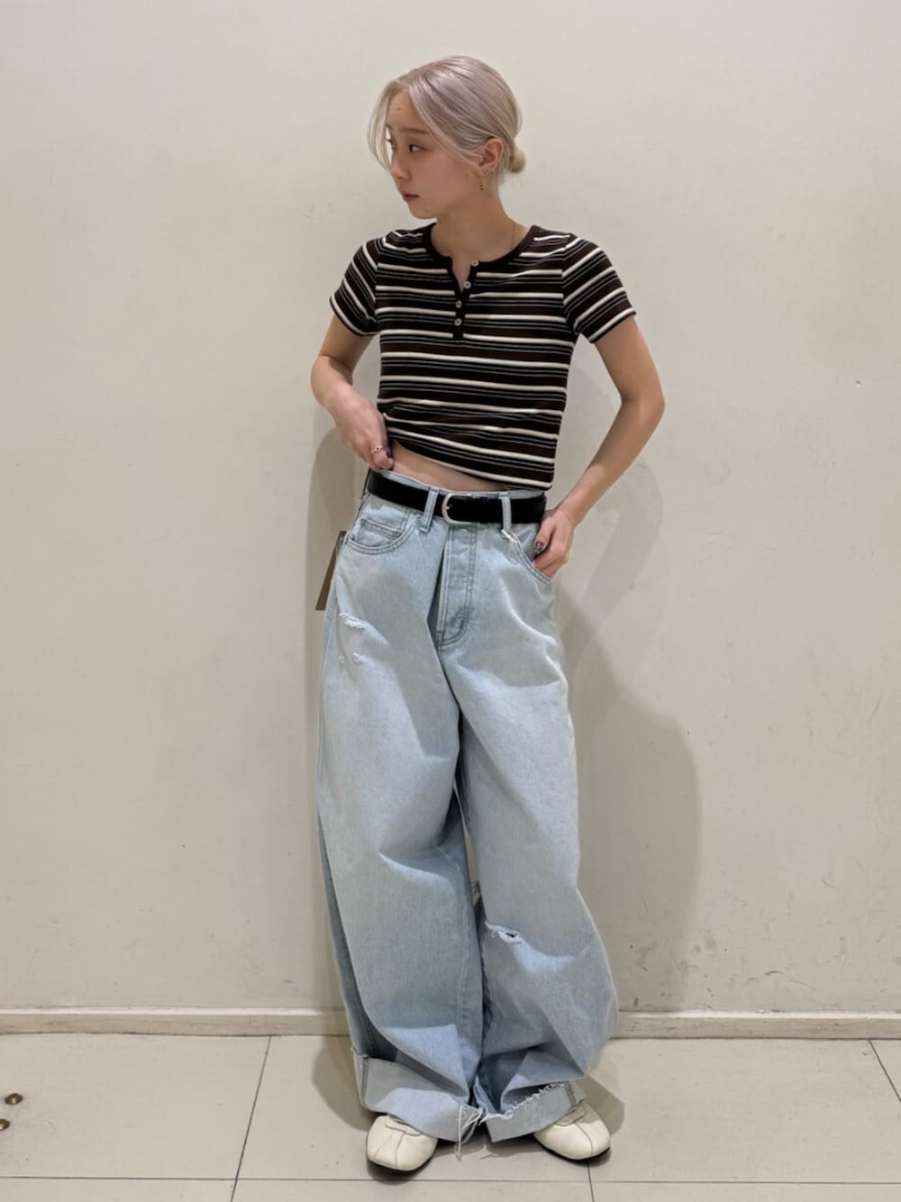 ブルー系のデニムパンツ、ブラウン系のTシャツ/カットソーを着用したレディースの春コーディネートの1枚目の写真