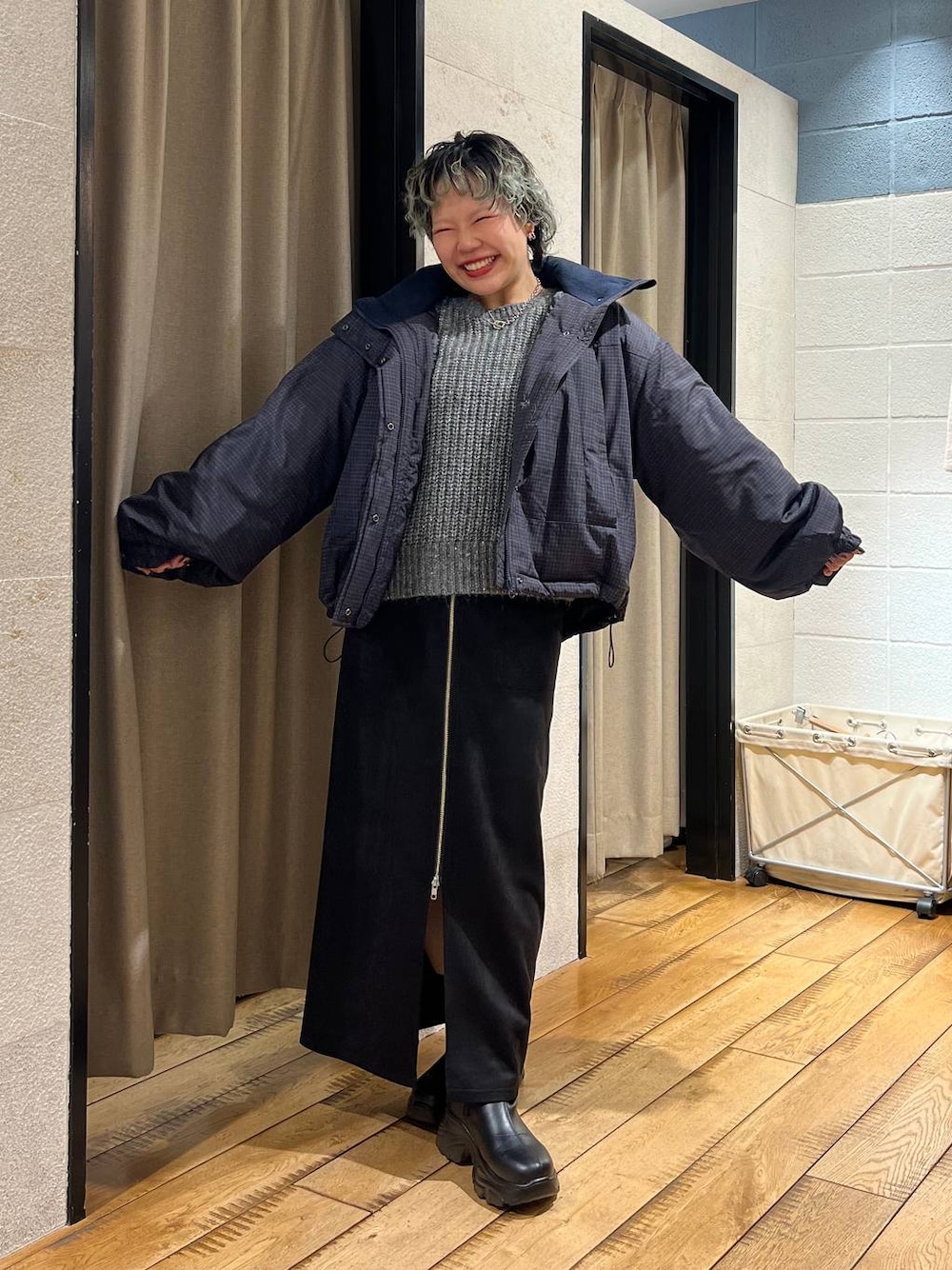 ブラック系のブーツ、ブラック系のスカート、グレー系のニット/セーターを着用したレディースの冬コーディネートの1枚目の写真