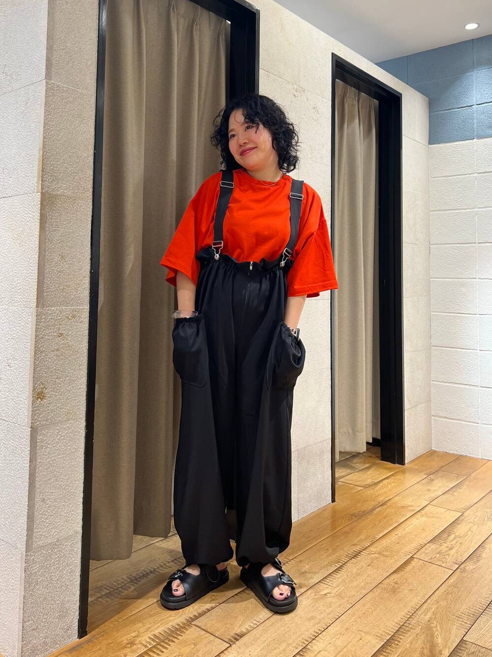 ブラック系のサンダル、レッド系のTシャツ/カットソー、ブラック系のワンピースを着用したレディースの夏コーディネートの1枚目の写真