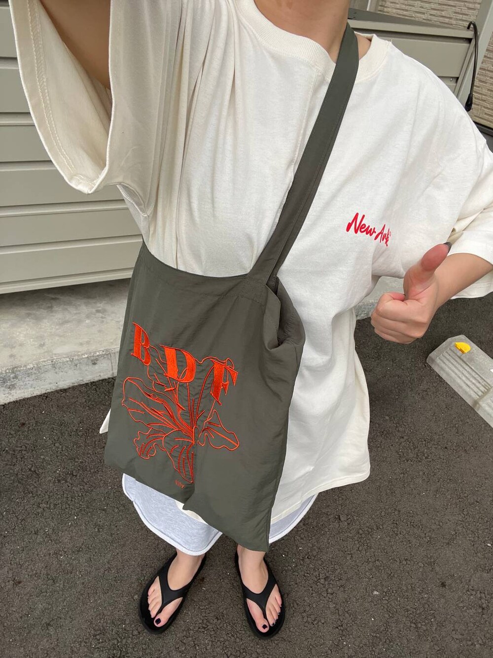 グレー系のスウェットパンツ、ホワイト系のチュニックを着用したレディースの夏コーディネートの1枚目の写真