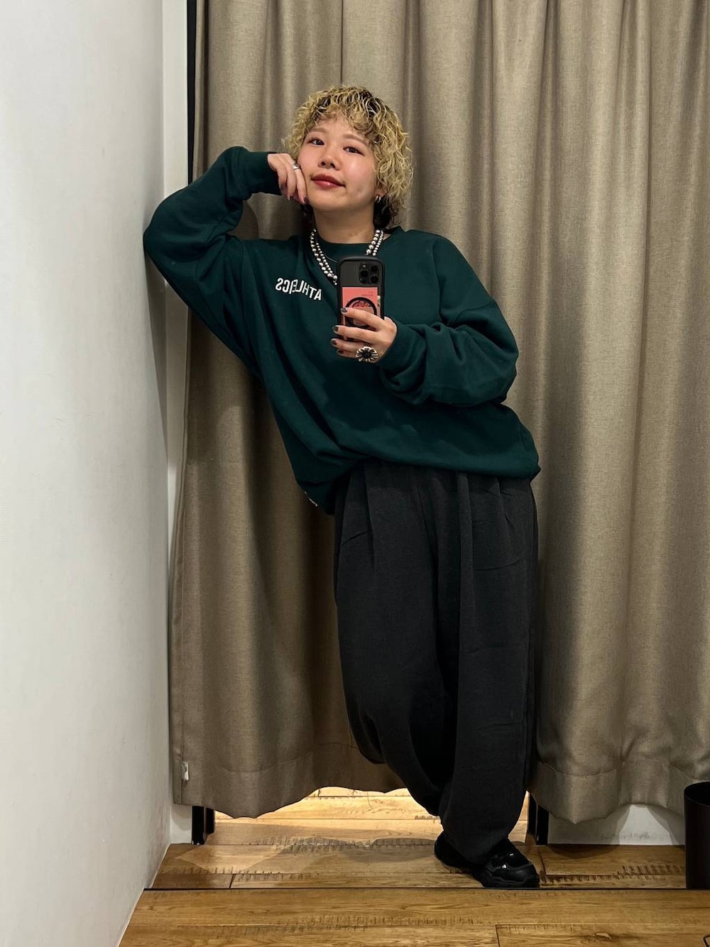 グレー系のその他パンツ、グリーン系のスウェット、シルバー系のネックレスを着用したレディースの秋コーディネートの1枚目の写真