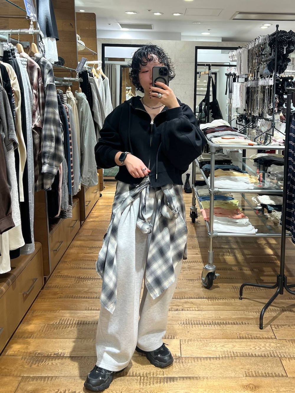 グレー系のスウェットパンツ、ブラック系のパーカー、グレー系のシャツ/ブラウスを着用したレディースの秋コーディネートの1枚目の写真