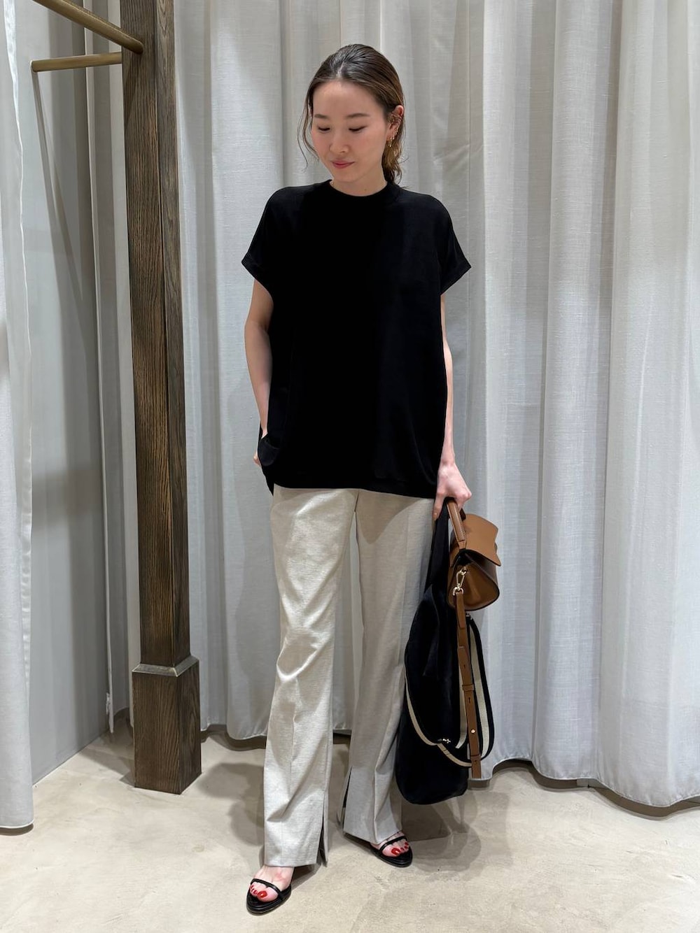 ブラック系のトートバッグ、ベージュ系のその他パンツ、ブラック系のニット/セーターを着用したレディースの春コーディネートの1枚目の写真