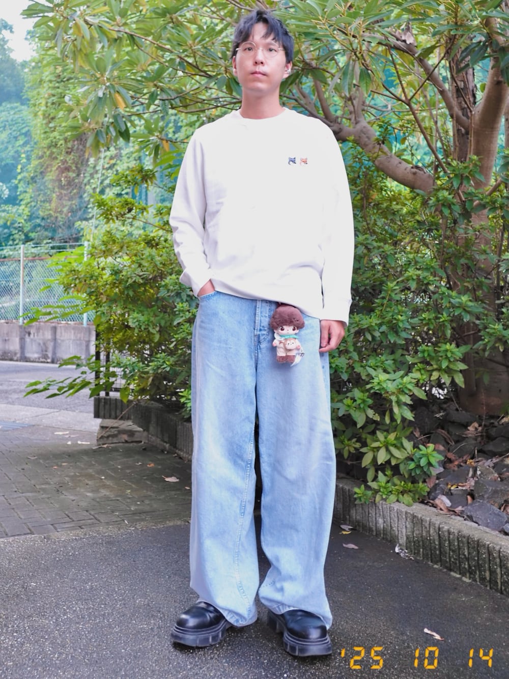 ホワイト系のスウェット、ブルー系のデニムパンツ、ブラック系のブーツを着用したメンズの秋コーディネートの1枚目の写真