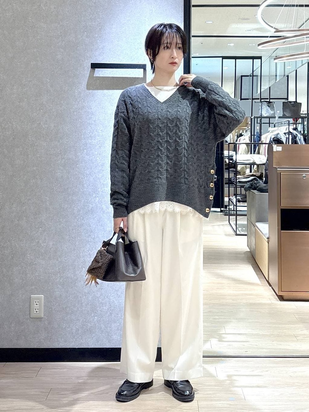 ホワイト系のシャツ/ブラウス、グレー系のニット/セーター、ホワイト系のその他パンツを着用したレディースの冬コーディネートの1枚目の写真