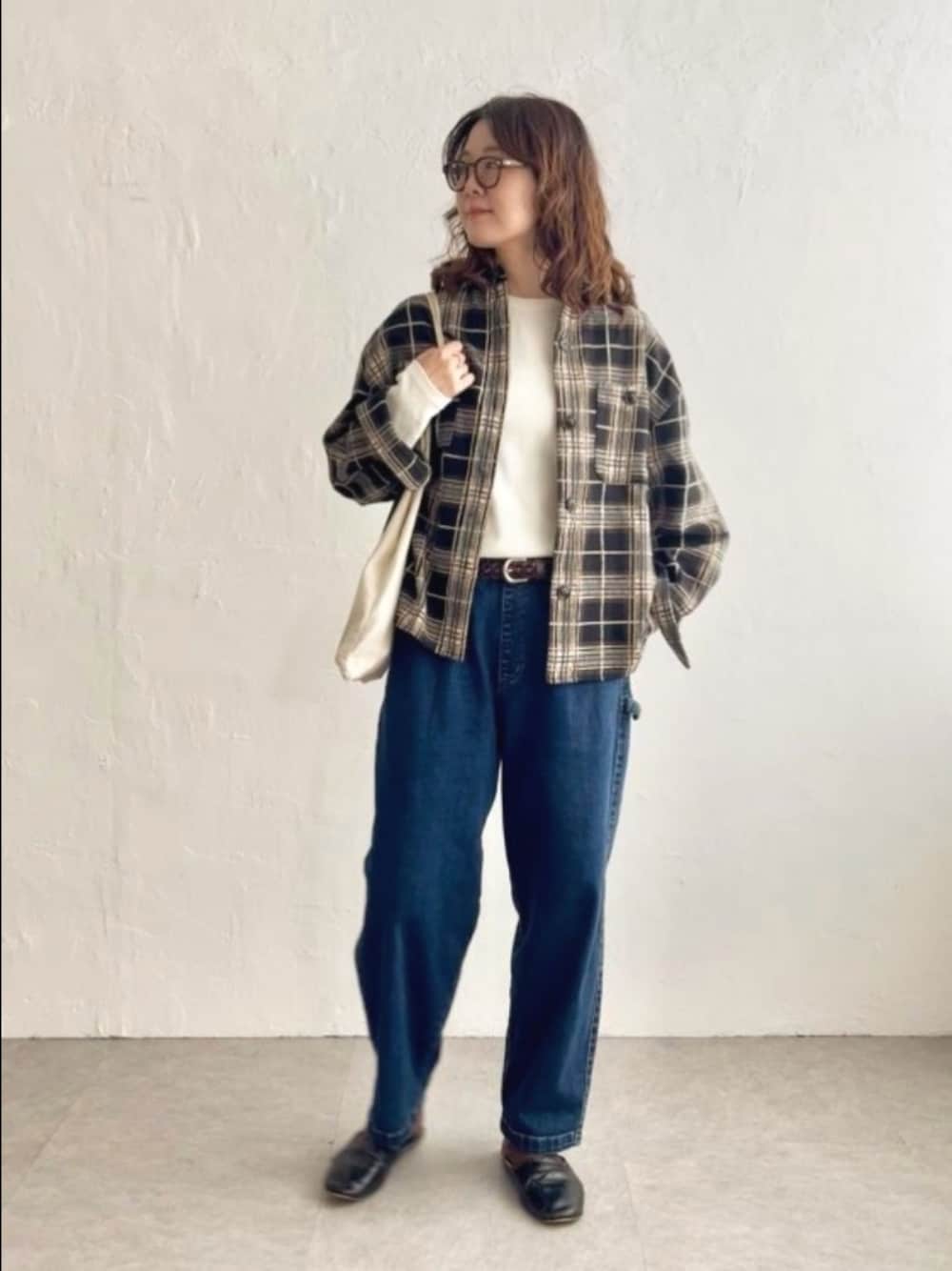 ブラック系のシャツ/ブラウス、ブルー系のデニムパンツを着用したレディースの秋コーディネートの1枚目の写真