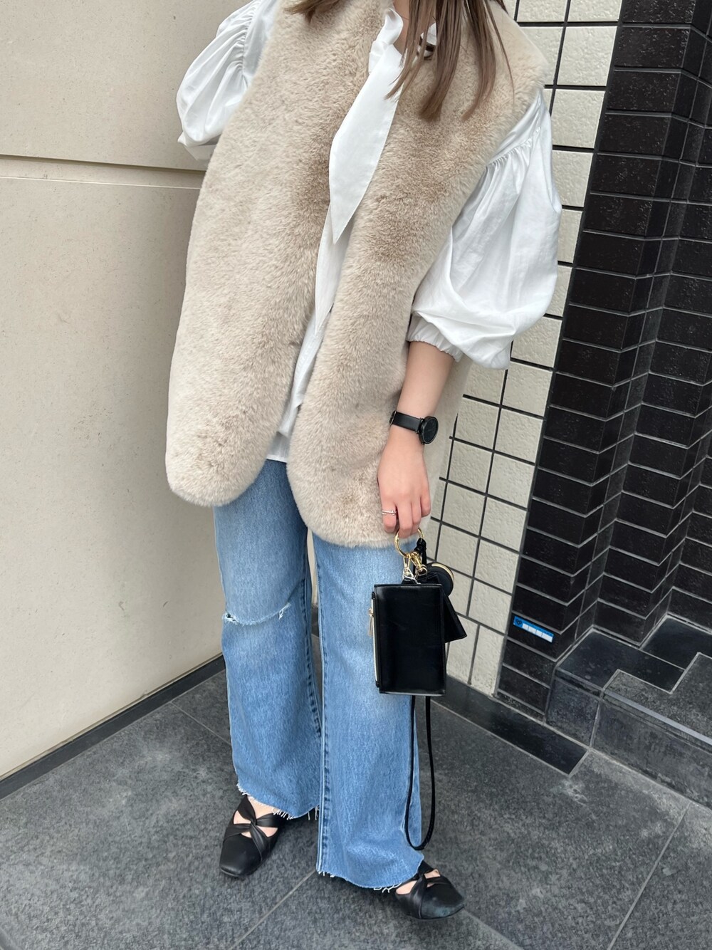 ホワイト系のシャツ/ブラウス、ベージュ系のベスト、パープル系のショルダーバッグを着用したレディースの春コーディネートの2枚目の写真