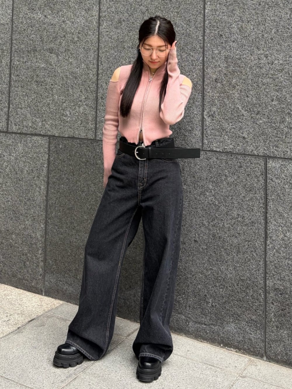 ピンク系のニット/セーター、ブルー系のデニムパンツ、ブラック系のブーツを着用したレディースの春コーディネートの1枚目の写真