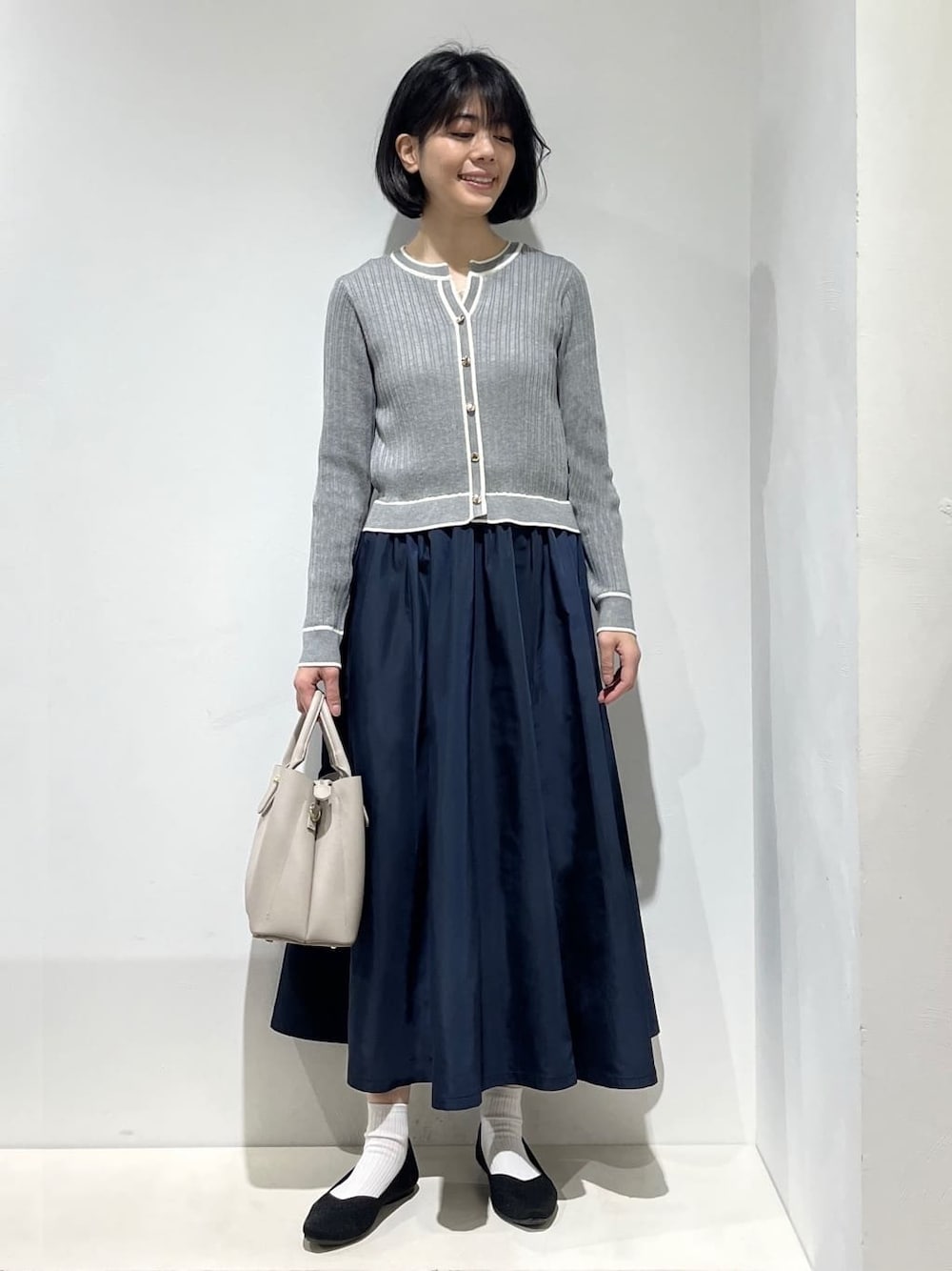グレー系のワンピース、ホワイト系のタンクトップ、グレー系のトートバッグを着用したレディースの春コーディネートの1枚目の写真