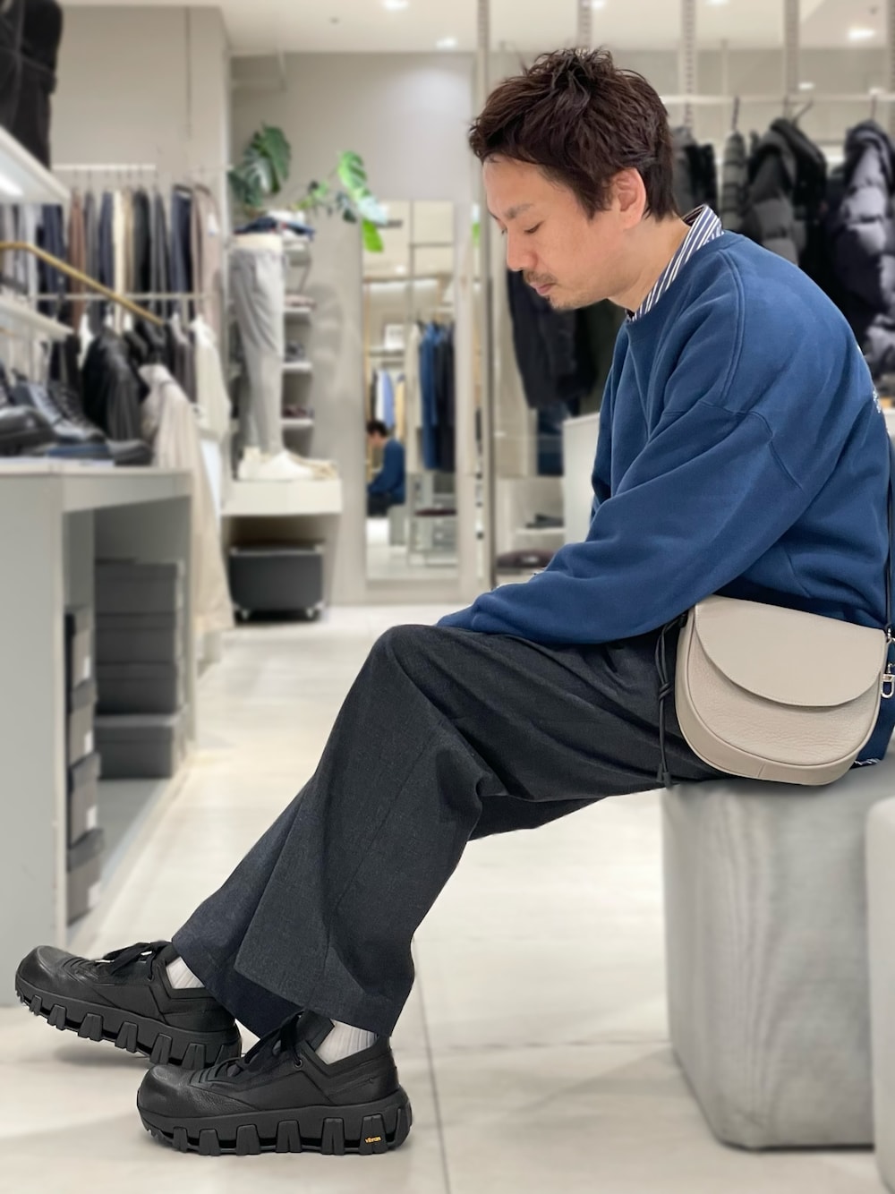 ブラック系のスニーカー、グレー系のショルダーバッグを着用したメンズの冬コーディネートの1枚目の写真
