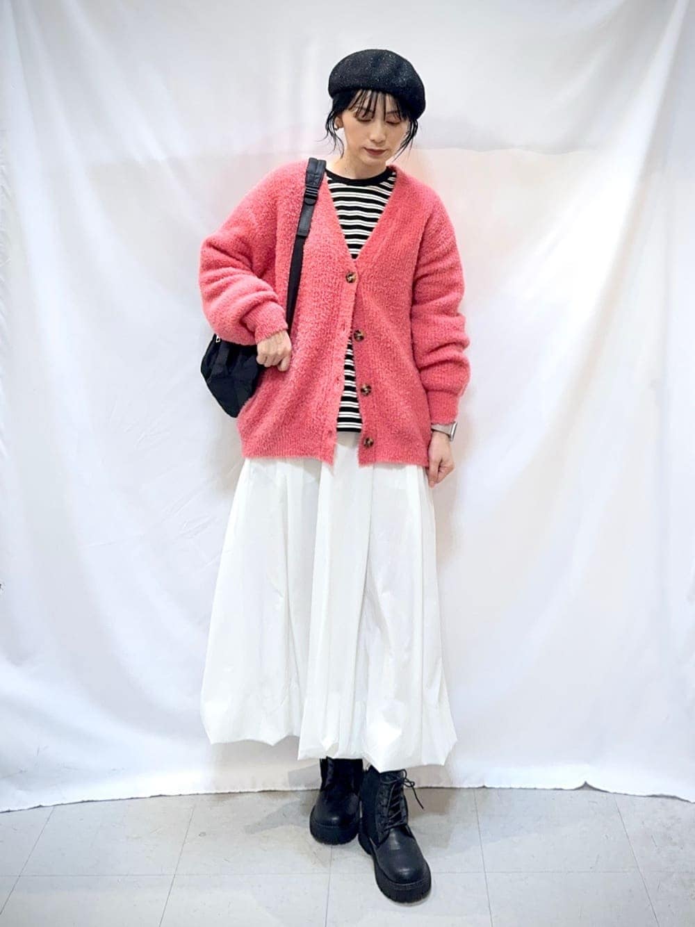 ピンク系のカーディガン/ボレロ、ブラック系のTシャツ/カットソー、ホワイト系のスカートを着用したレディースの秋コーディネートの1枚目の写真