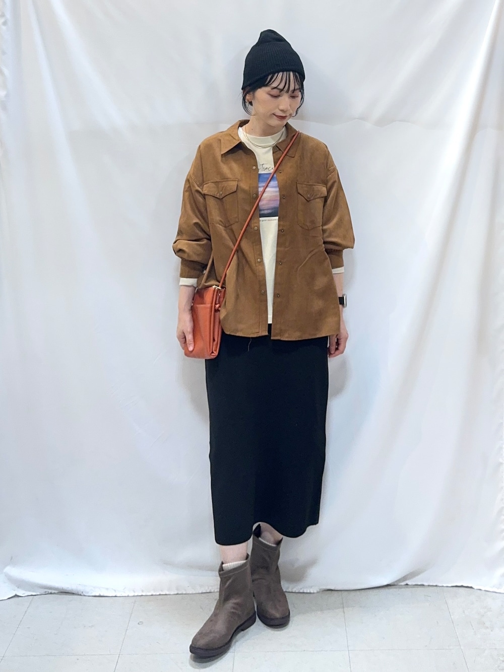 イエロー系のシャツ/ブラウス、ベージュ系のTシャツ/カットソー、ブラック系のスカートを着用したレディースの秋コーディネートの1枚目の写真