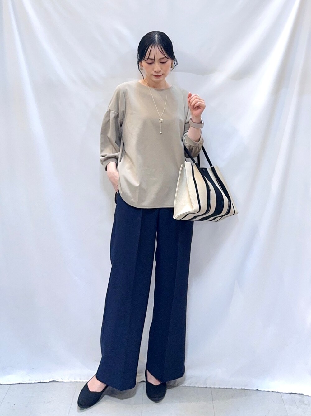 ブルー系のその他パンツ、ブラック系のパンプス、ブラック系のトートバッグを着用したレディースの秋コーディネートの1枚目の写真