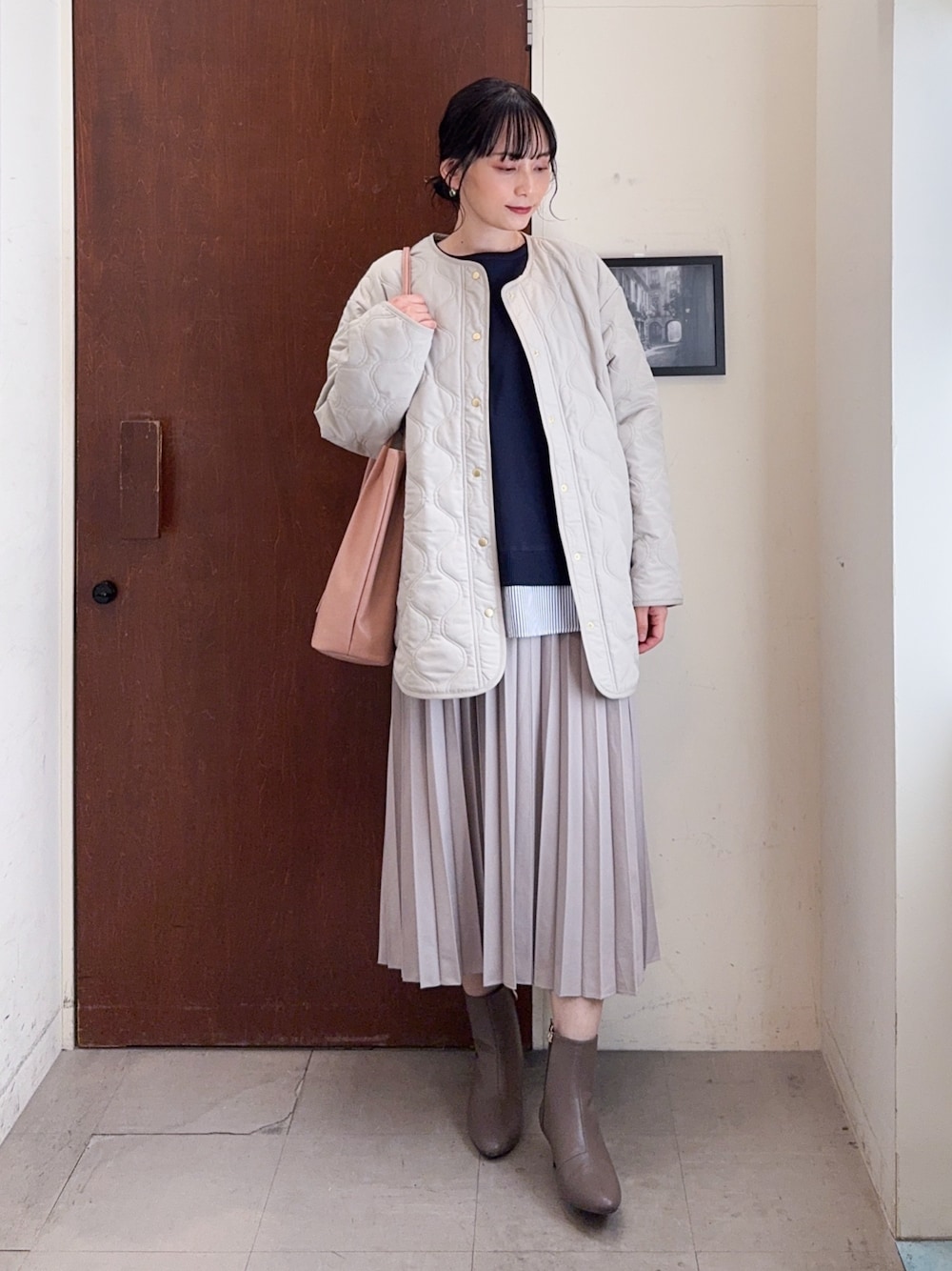 ベージュ系のブルゾン、ブルー系のニット/セーター、ベージュ系のスカートを着用したレディースの冬コーディネートの1枚目の写真