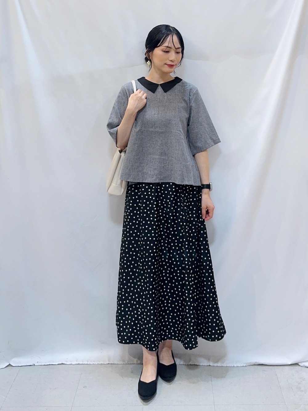 グレー系のシャツ/ブラウス、ブラック系のスカート、ブラック系のパンプスを着用したレディースの夏コーディネートの1枚目の写真