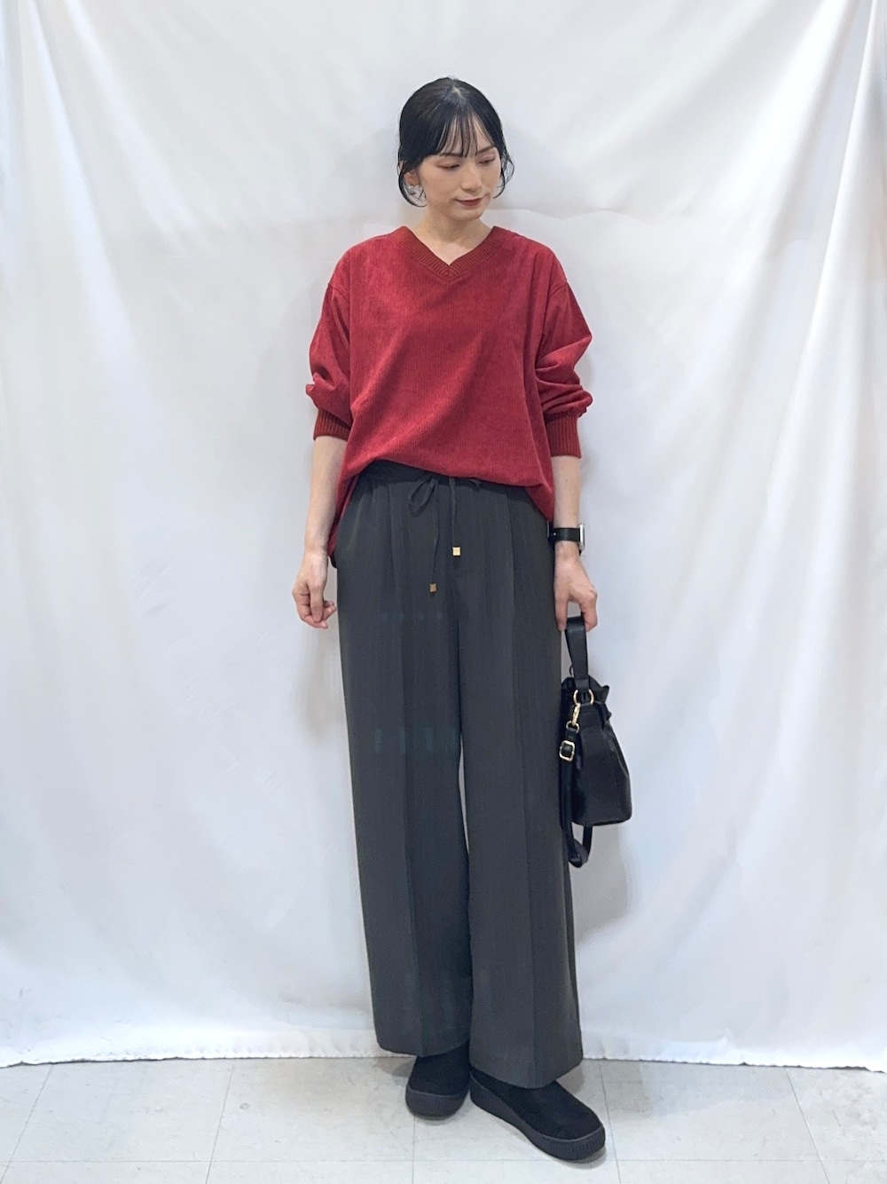 レッド系のTシャツ/カットソー、グレー系のその他パンツ、ブラック系のブーツを着用したレディースの秋コーディネートの1枚目の写真
