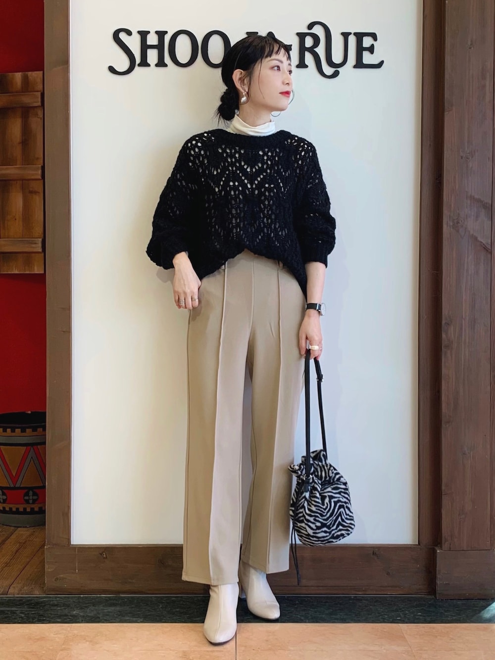 ブラック系のニット/セーター、ホワイト系のTシャツ/カットソー、ベージュ系のその他パンツを着用したレディースの冬コーディネートの1枚目の写真