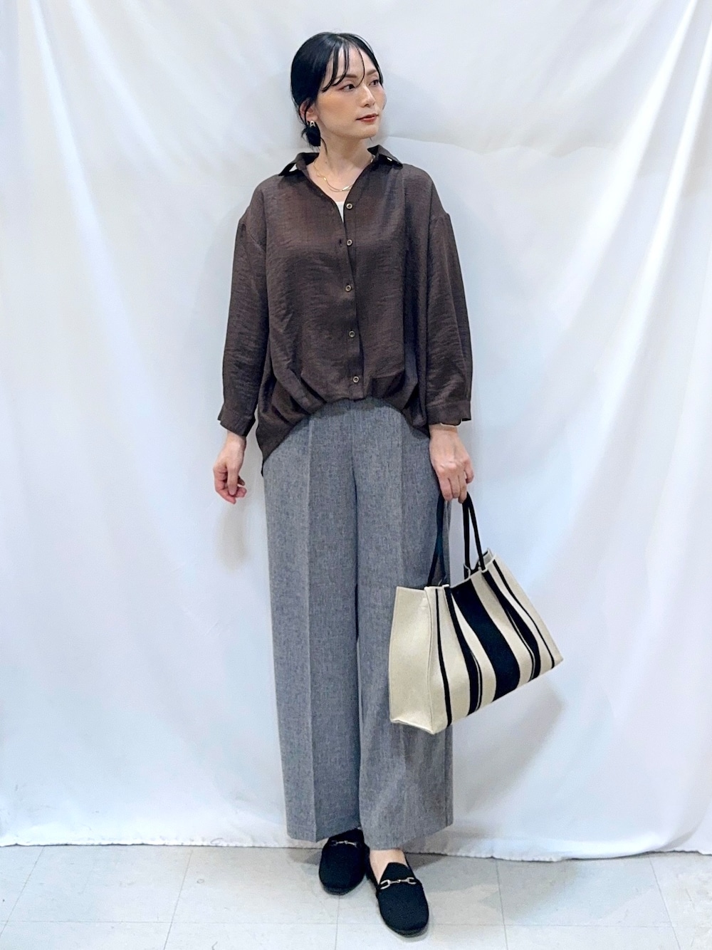グレー系のその他パンツ、ブラック系のその他シューズ、ブラック系のトートバッグを着用したレディースの秋コーディネートの1枚目の写真