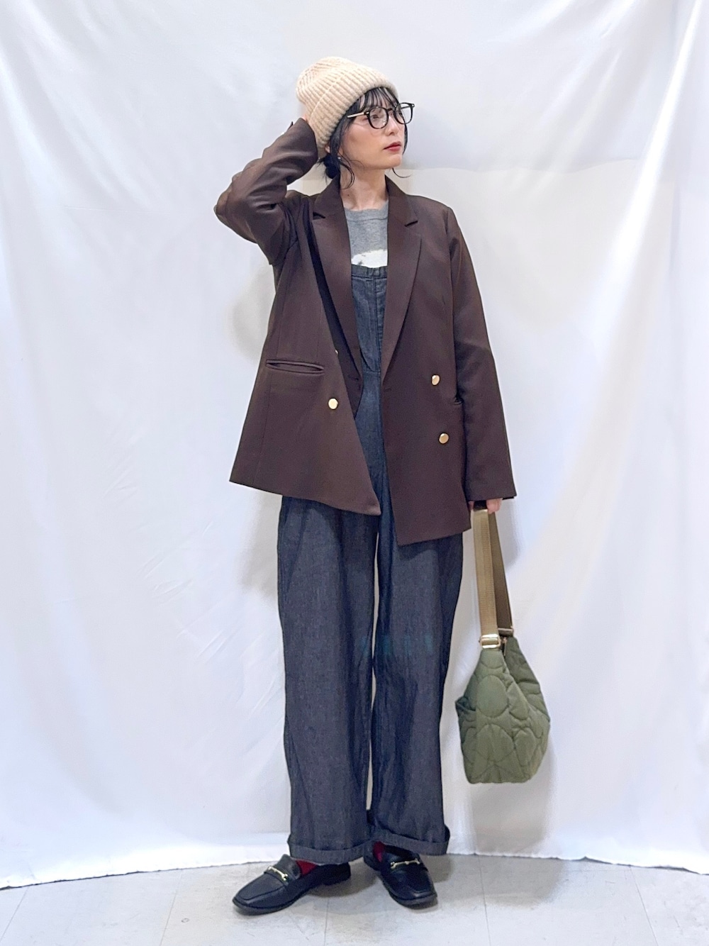 ブラウン系のテーラードジャケット、グレー系のニット/セーター、ブラック系のサロペット/オーバーオールを着用したレディースの秋コーディネートの1枚目の写真