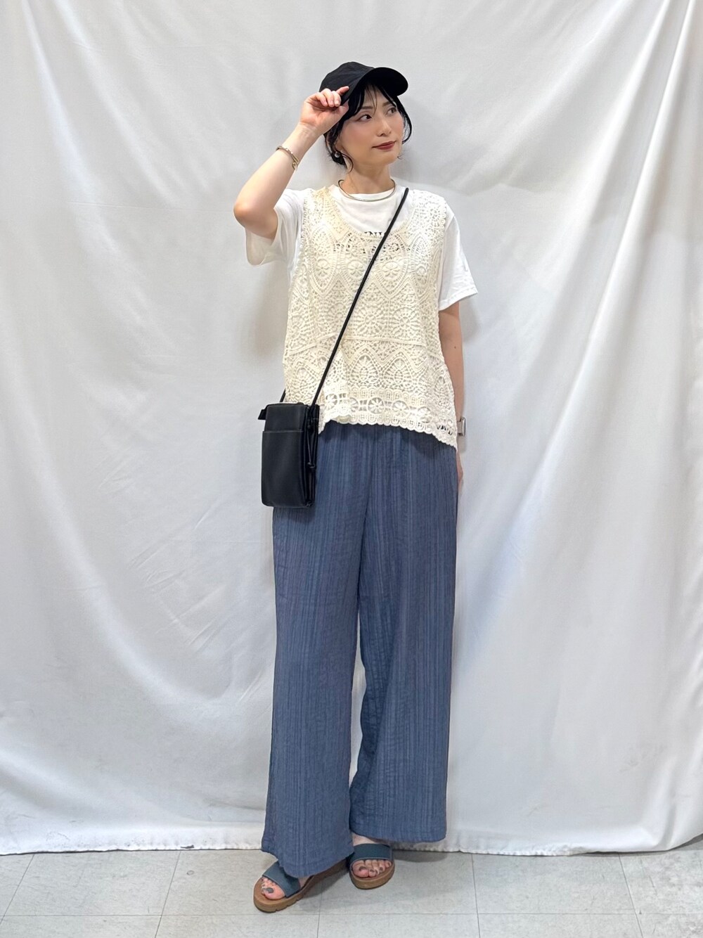 ブルー系のその他パンツ、ブルー系のサンダル、ブラック系のショルダーバッグを着用したレディースの夏コーディネートの1枚目の写真
