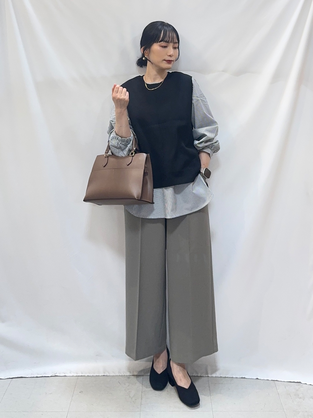 ベージュ系のその他パンツ、ブラック系のパンプス、ブラウン系のトートバッグを着用したレディースの秋コーディネートの1枚目の写真