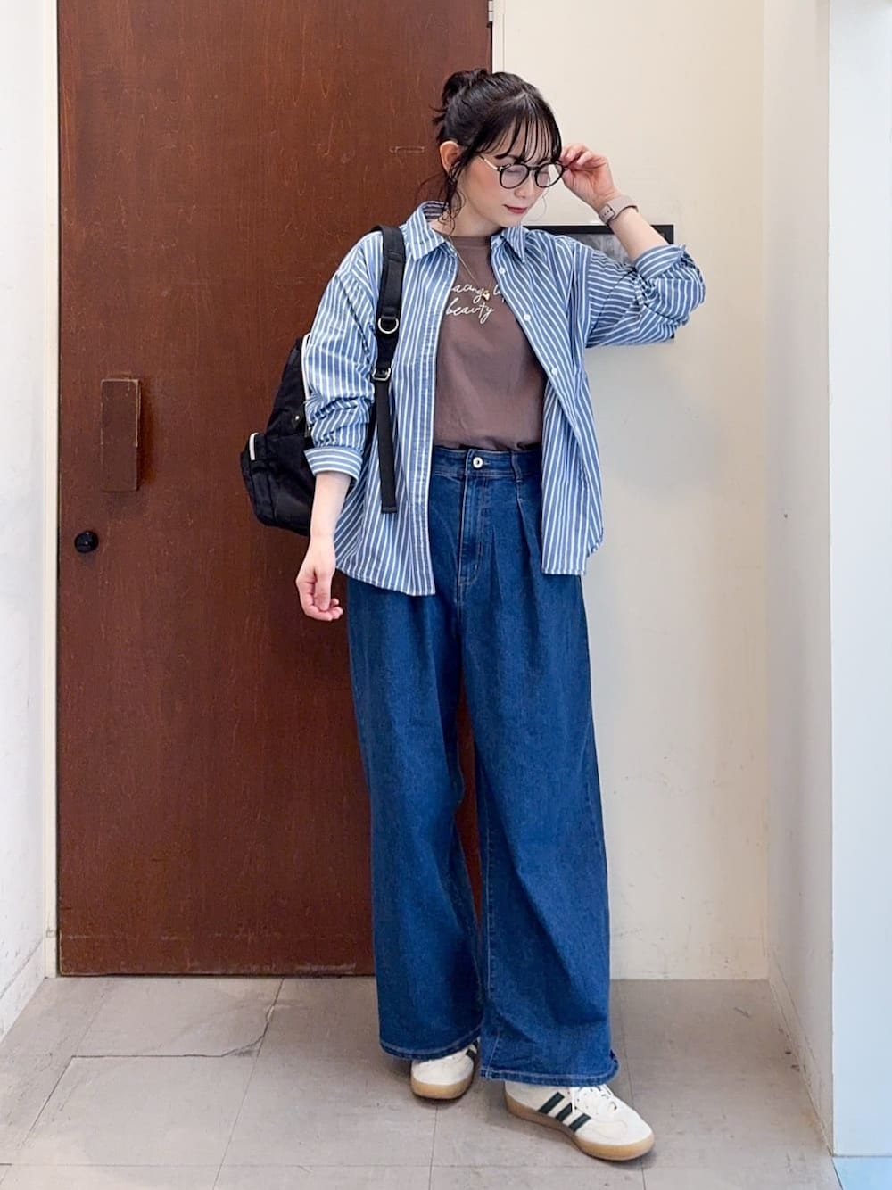 ブルー系のシャツ/ブラウス、ブラウン系のTシャツ/カットソー、ブルー系のデニムパンツを着用したレディースの春コーディネートの1枚目の写真