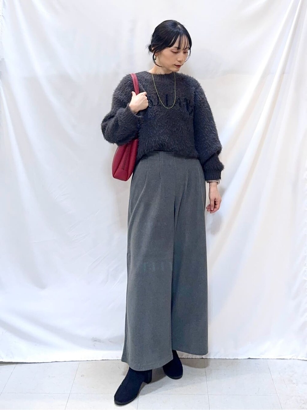 グレー系のニット/セーター、グレー系のその他パンツ、ブラック系のブーツを着用したレディースの冬コーディネートの1枚目の写真