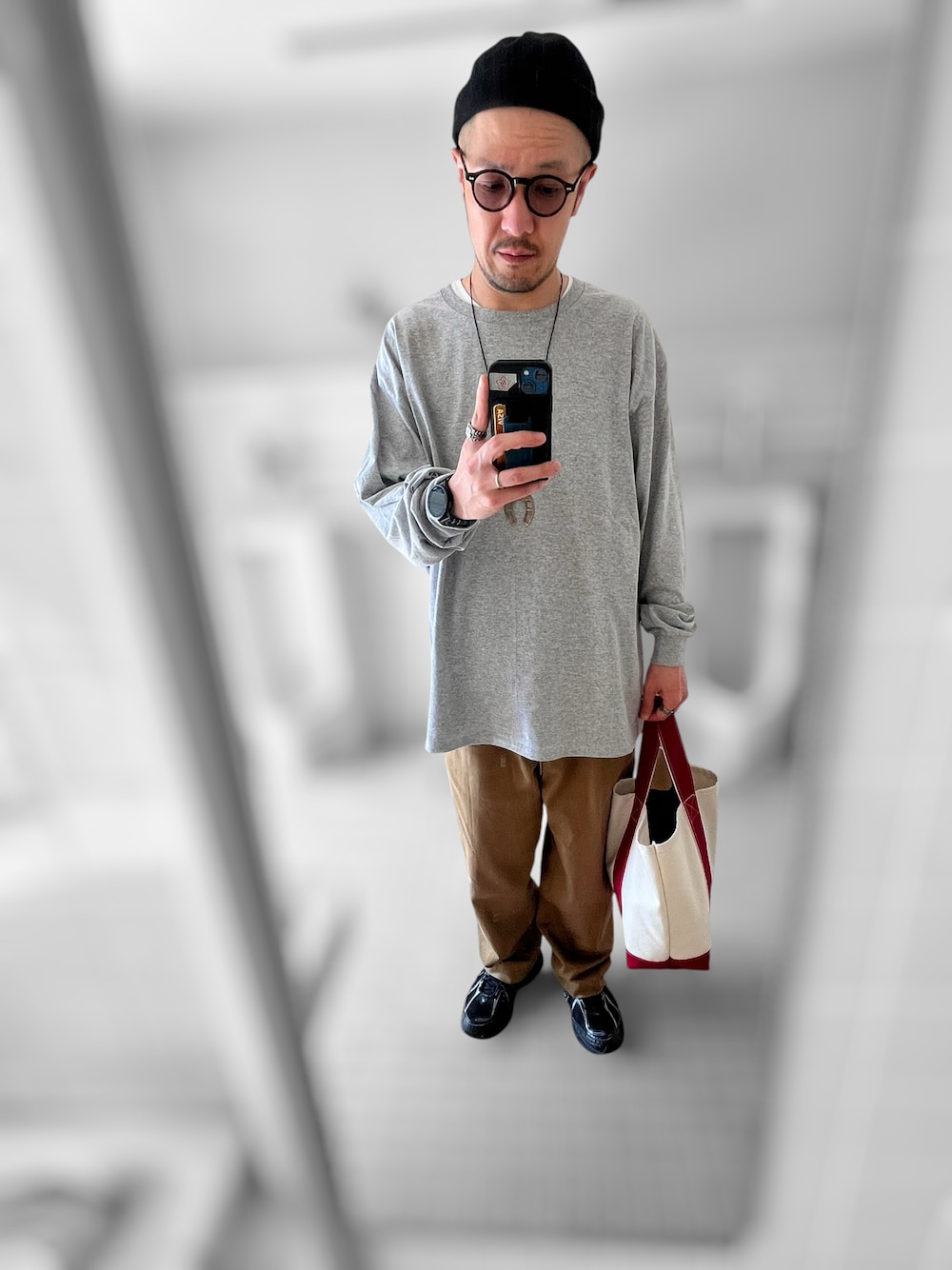 グレー系のTシャツ/カットソー、ブラック系のスニーカー、ブラウン系のチノパンツを着用したメンズの春コーディネートの1枚目の写真