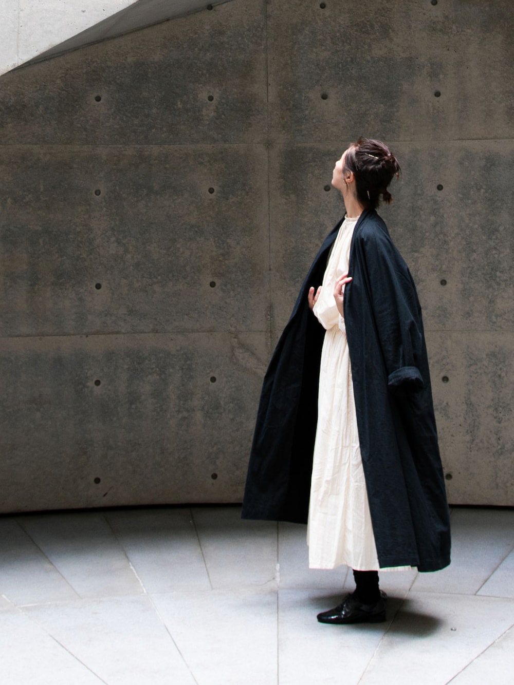 ブラック系のジャケット/アウター、イエロー系のスカート、ベージュ系のシャツ/ブラウスを着用したレディースの冬コーディネートの1枚目の写真