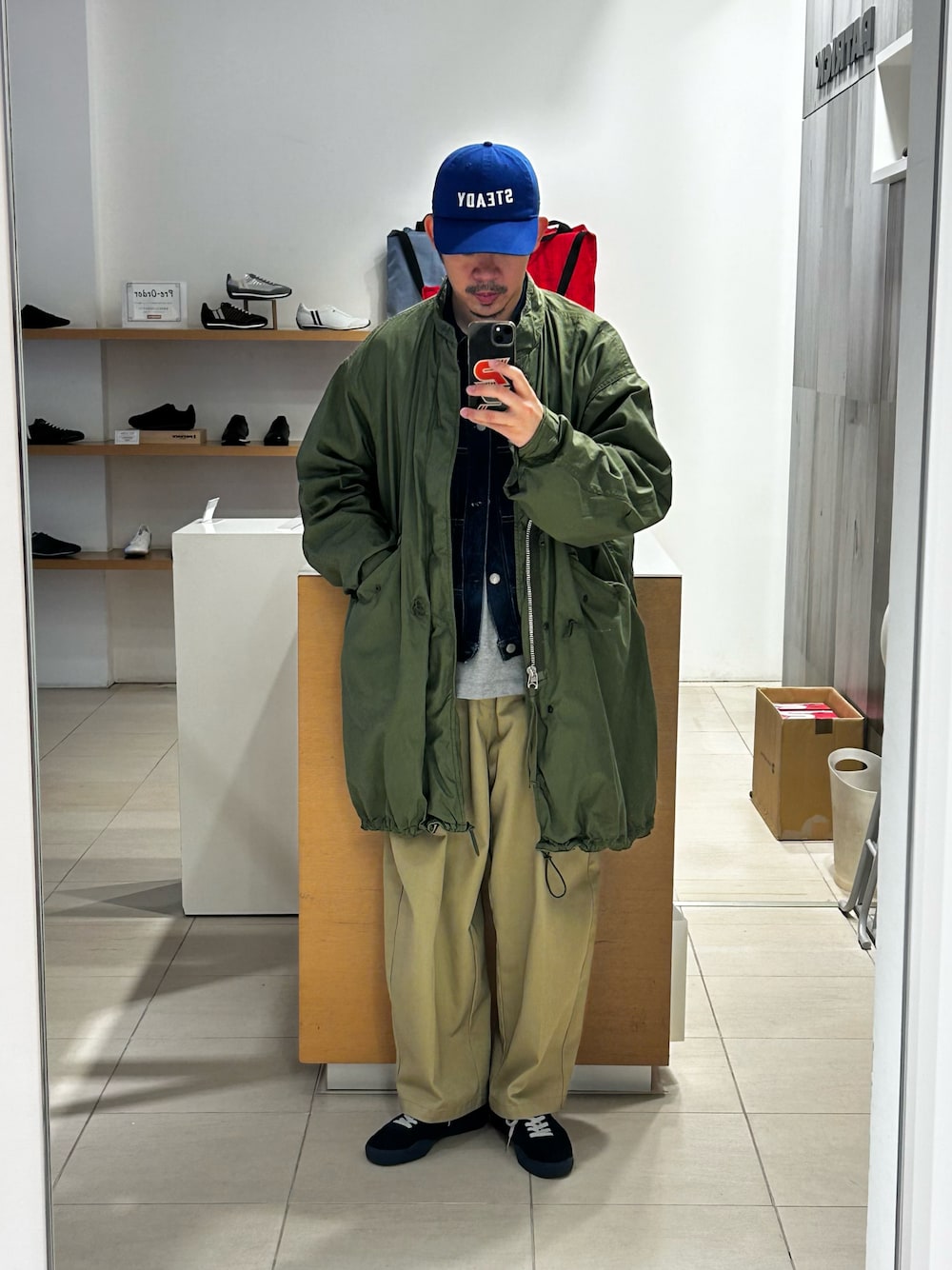 グリーン系のモッズコート、ブルー系のデニムジャケット、グレー系のTシャツ/カットソーを着用したメンズの冬コーディネートの1枚目の写真