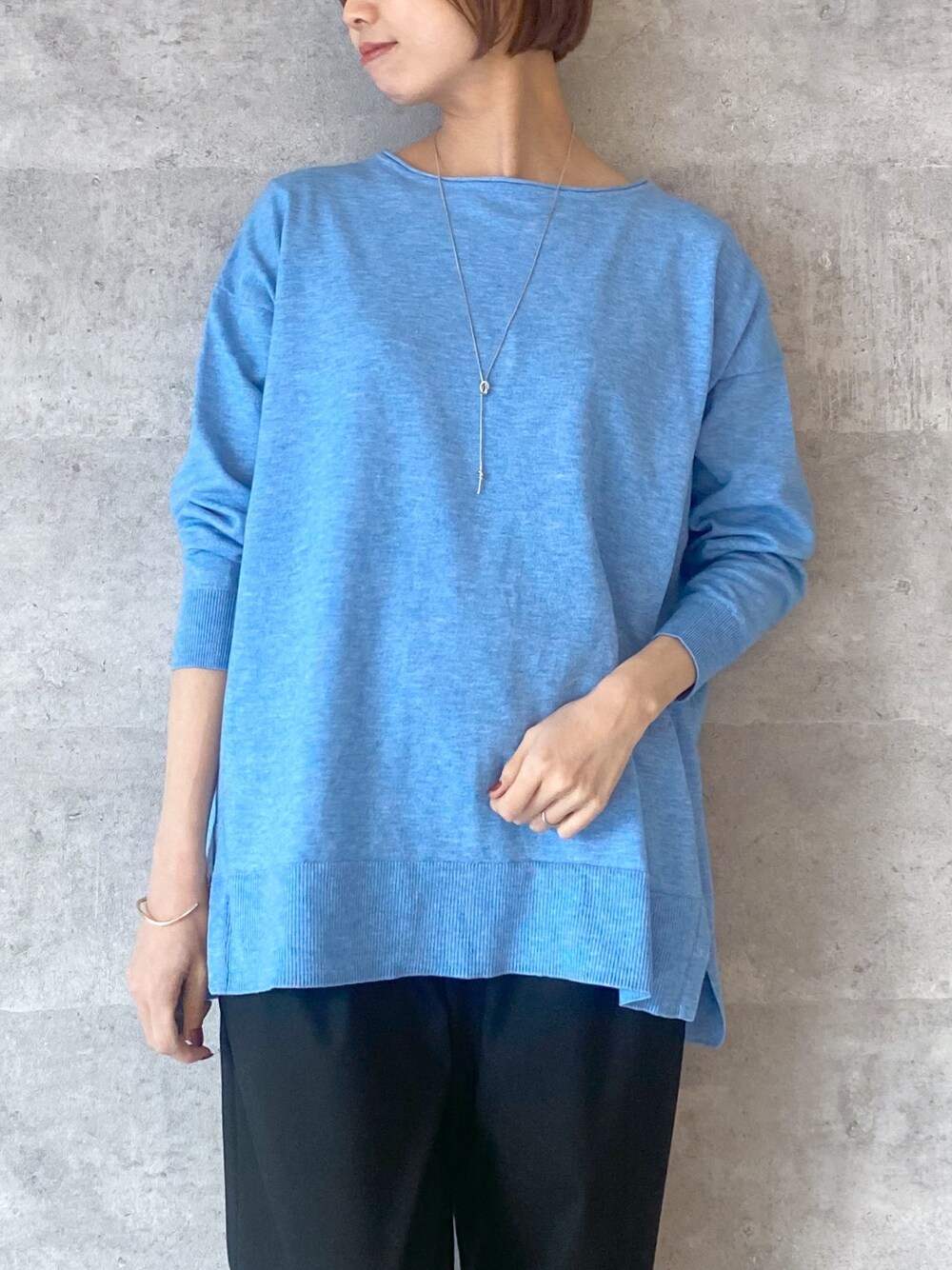 ブルー系のニット/セーター、ブルー系のショルダーバッグ、ブラック系のその他パンツを着用したレディースの冬コーディネートの2枚目の写真