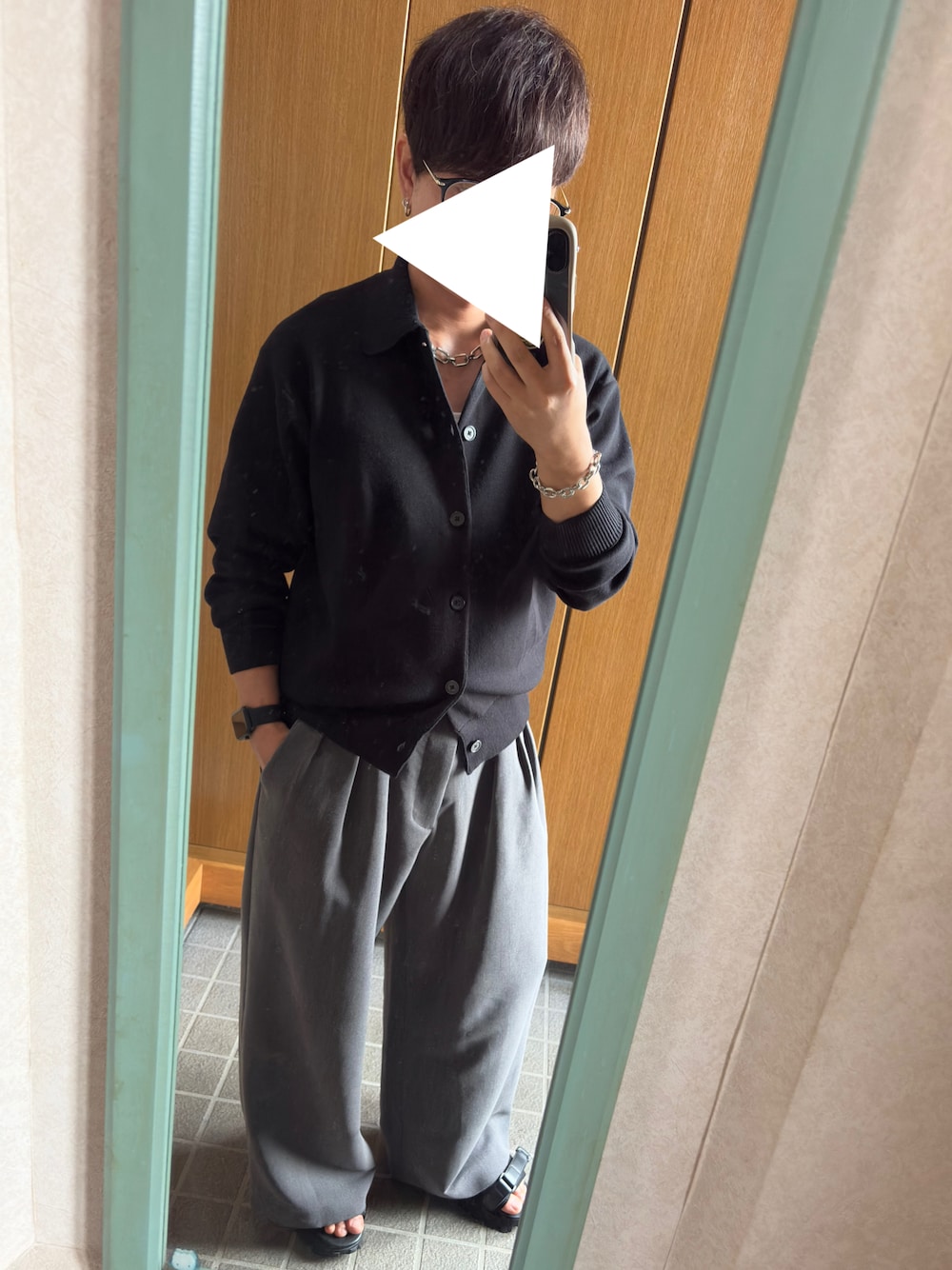 ホワイト系のタンクトップ、ブラック系のカーディガン/ボレロ、グレー系のスラックスを着用したメンズの秋コーディネートの1枚目の写真