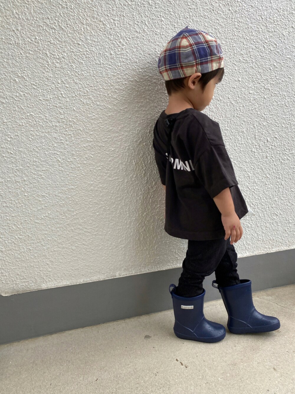 ブラック系のTシャツ/カットソー、ブルー系のレインシューズ、ブルー系のハンチング/ベレー帽を着用したキッズの秋コーディネートの1枚目の写真