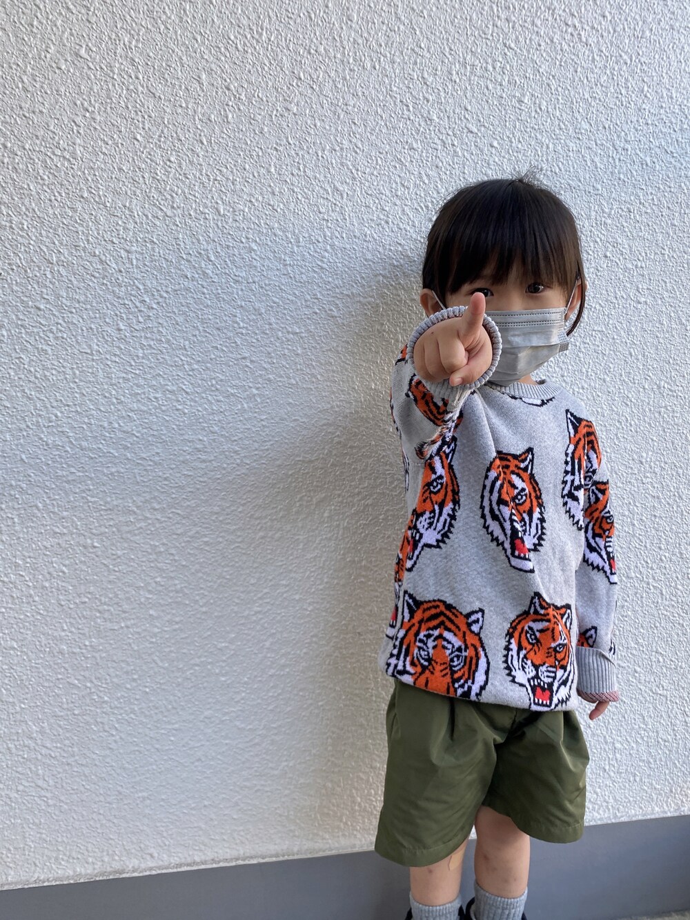 グレー系のニット/セーター、グリーン系のパンツを着用したキッズの冬コーディネートの1枚目の写真