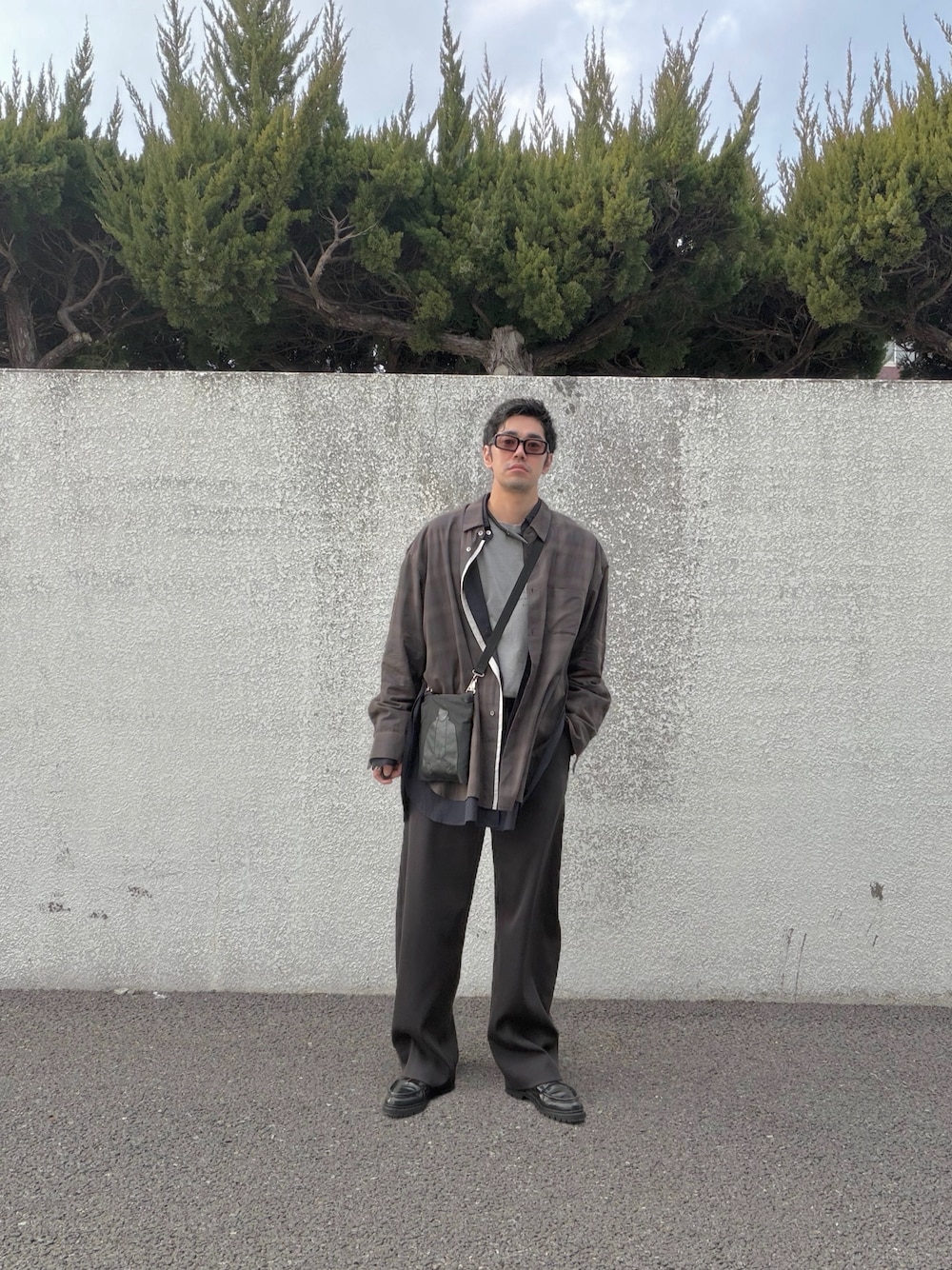 ブラウン系のスラックス、ブラウン系のシャツ/ブラウス、グレー系のTシャツ/カットソーを着用したメンズの冬コーディネートの1枚目の写真