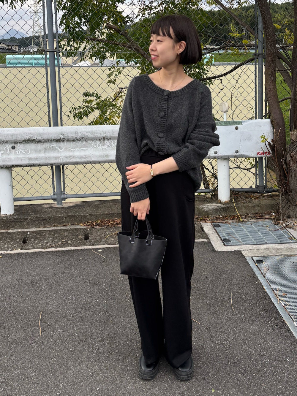 ブラック系のブーツ、グレー系のニット/セーター、ブラック系のパンツを着用したレディースの秋コーディネートの1枚目の写真