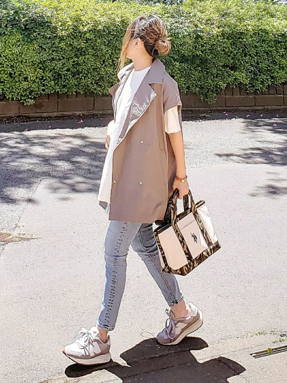 ホワイト系のトートバッグ、グレー系のミリタリージャケット、ホワイト系のTシャツ/カットソーを着用したレディースの春コーディネートの1枚目の写真