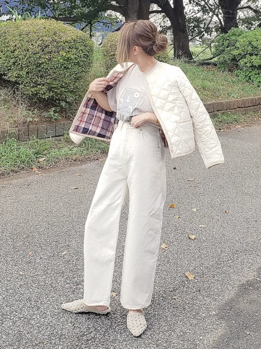 ホワイト系のブルゾン、ベージュ系のTシャツ/カットソー、ホワイト系のデニムパンツを着用したレディースの秋コーディネートの1枚目の写真