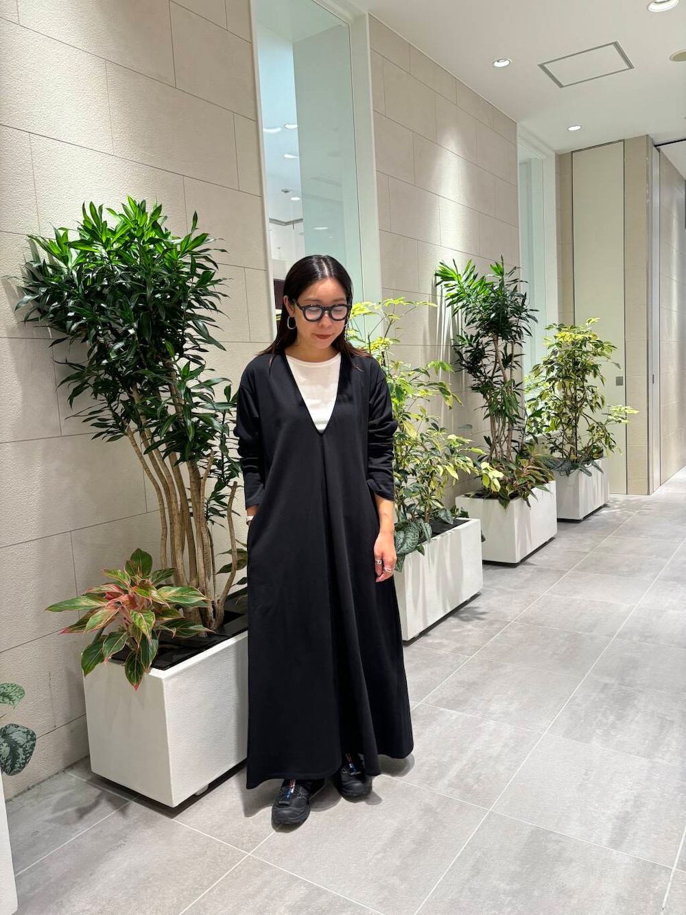 ホワイト系のタンクトップ、ブラック系のスニーカー、ブラック系のワンピースを着用したレディースの夏コーディネートの1枚目の写真