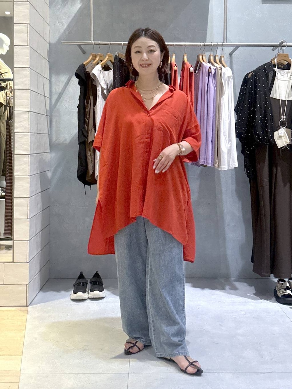 レッド系のシャツ/ブラウス、ブルー系のデニムパンツ、ゴールド系のネックレスを着用したレディースの夏コーディネートの1枚目の写真
