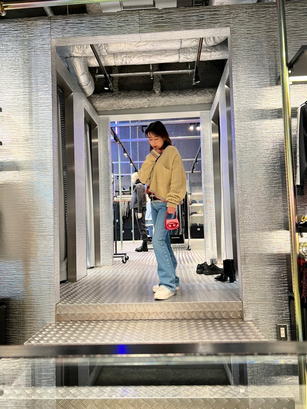 ブルー系のデニムパンツ、ホワイト系のスニーカー、ホワイト系のカーディガン/ボレロを着用したレディースの冬コーディネートの1枚目の写真