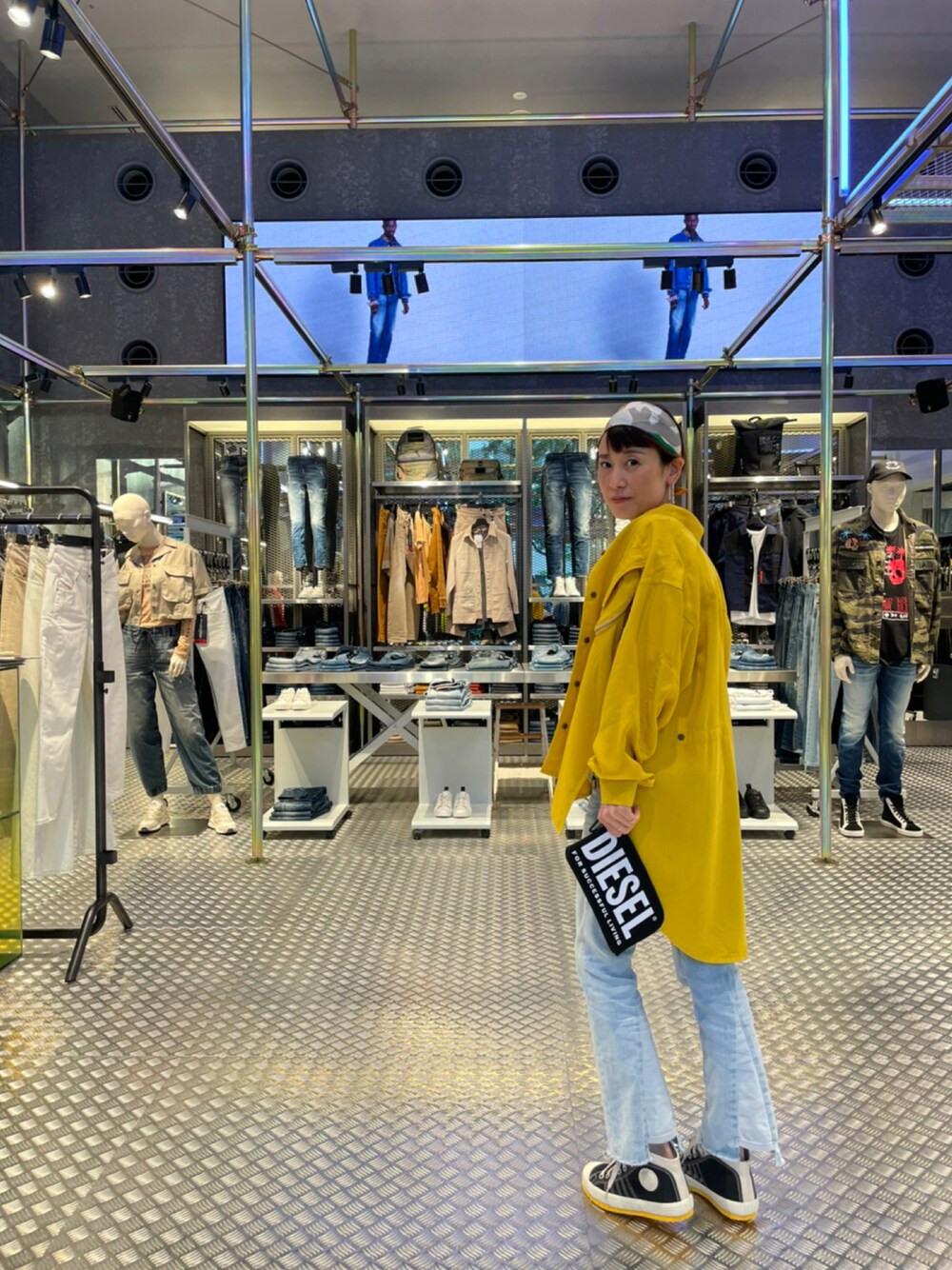 イエロー系のシャツ/ブラウス、ブルー系のデニムパンツ、ブラック系のスニーカーを着用したレディースの夏コーディネートの1枚目の写真