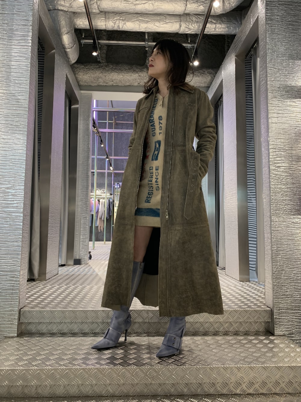 グリーン系のジャケット/アウター、ブルー系のシューズ、ベージュ系のワンピース/ドレスを着用したレディースの冬コーディネートの1枚目の写真